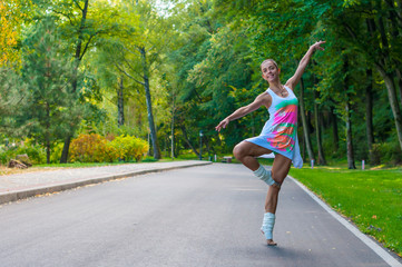 Girl dancer stands on tiptoes, ballet pirouette. Outdoors