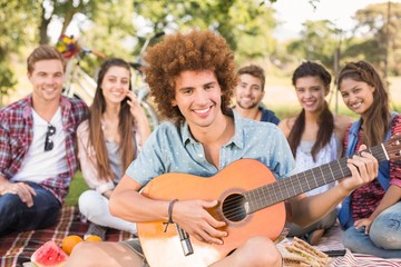 Happy friends in the park having picnic