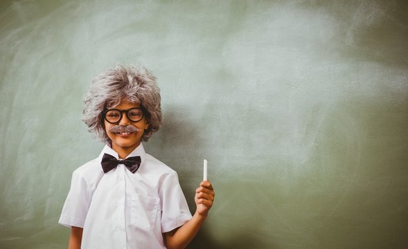Boy dressed as senior teacher in front of blackboard