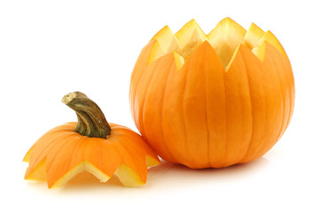 An orange Halloween pumpkin cut open on a white background