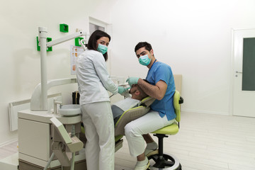 Portrait Of A Dentist With His Assistant