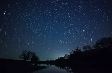 Fototapete Rund ein wunderschöner Nachthimmel, Milchstraße, Sternenspuren und die Bäume © snike