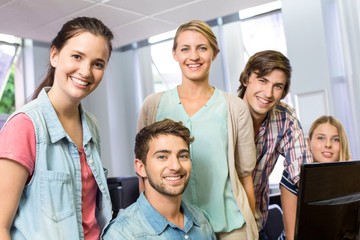 Happy female computer teacher and students