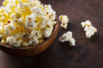 Fresh popcorn in bowl on wooden table