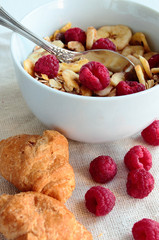 Bowl with cereals with fresh berries and croissants