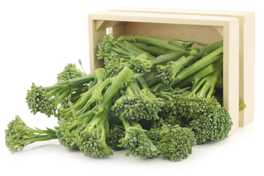 A small form of broccoli, called bimi, in a wooden box on a whit
