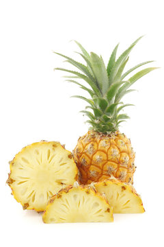 fresh mini pineapple fruit and a cut one on a white background