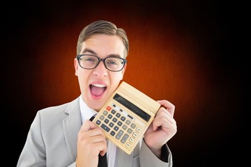 Composite image of geeky smiling businessman showing calculator