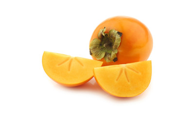 fresh kaki fruit and some cut pieces on a white background