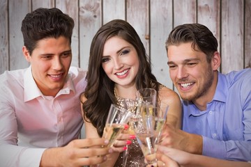 Composite image of friends toasting with champagne