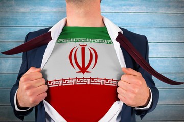 Composite image of businessman opening shirt to reveal iran flag