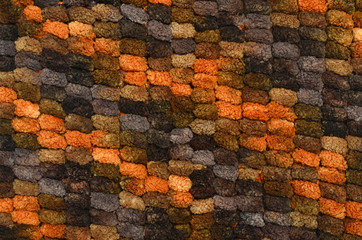 Knit woolen texture.Orange brown woven thread knots background.