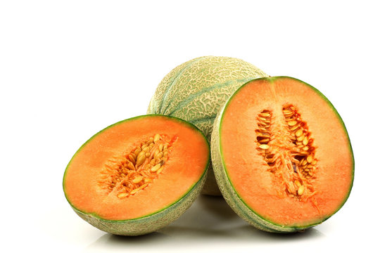 one whole cantaloupe melon and two halves on a white background