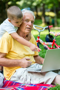 grandfather and child using laptop