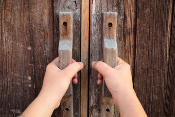 Hand on a handle wooden door