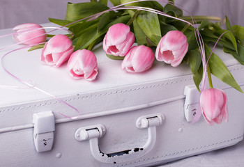 Obraz na płótnie Canvas Pink tulips, white vintage suitcases.
