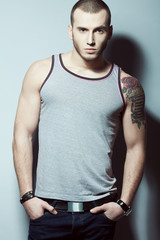 Portrait of tattooed brutal young man with short hair & bristle