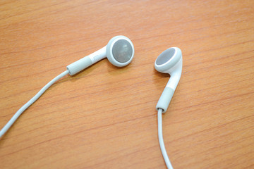 white earphones on wooden background