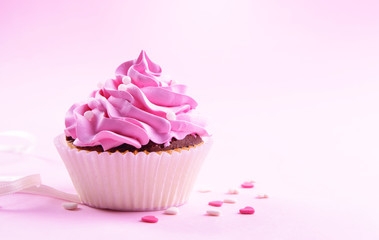 Delicious cupcake on pink background