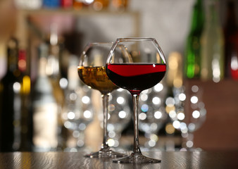 Two glasses of wine with bar on background