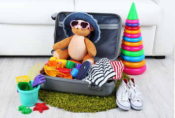 Suitcase packed with clothes and child toys