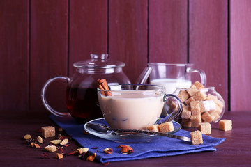 Black tea with milk and lump sugar and spices  in glassware