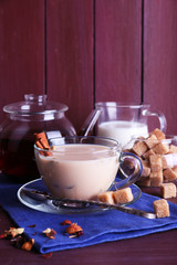 Black tea with milk and lump sugar and spices  in glassware
