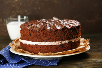 Obraz na płótnie Canvas Delicious chocolate cake on table on brown background