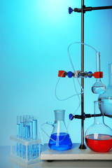 Fixed laboratory glassware on support on colorful background