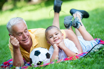 Fototapeta na wymiar grandfather and child have fun in park
