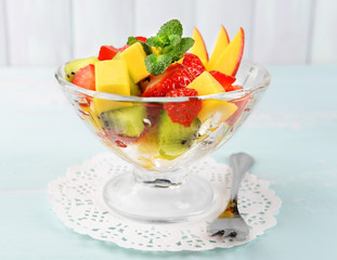 Fruit salad in glassware on wooden table and planks background
