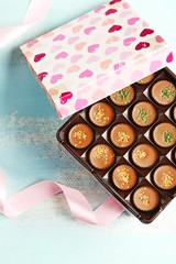 Gift box with tasty chocolate candies on wooden table