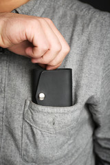 Man hand made leather wallet in pocket, close up