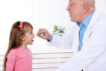 Little girl and old doctor in hospital