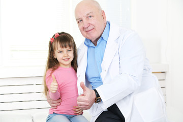 Obraz premium Little girl and old doctor in hospital