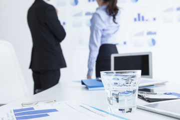 Men and women are looking at the graph on the wall