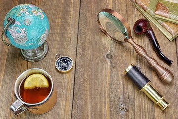 Fototapeta na wymiar Tea Mag On Grunge Wood Table With Many Travel Objects
