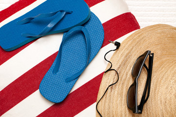 Flip flops, hat, towel, sunglasses and earphones for a day at th