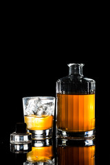 A glass of of Whiskey on the rocks against dark background