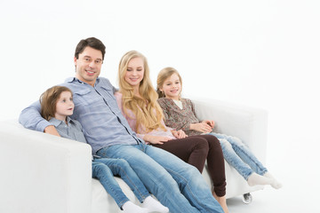 Happy family  with children sitting on the sofa at home