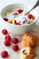 Bowl with oat cereals with milk and raspberry fruits