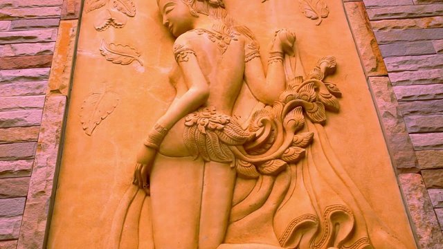 Thai ancient stone carving in woman view on wall. Macro video