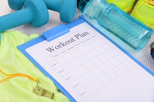 Workout plan and sports equipment top view close-up
