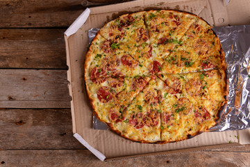 Tasty pizza in box on wooden background