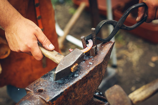 Blacksmith hammering a hot metal rod