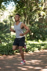 Attractive Black man running, exercising , stretching outside Pa