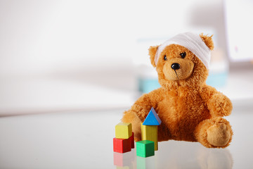 Bandaged Teddy Bear with Block Shapes on the Table