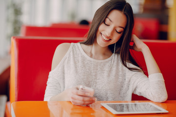 beautiful young girl enjoys phone and tablet
