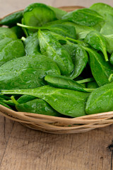 spinach in a basket on wooden surface