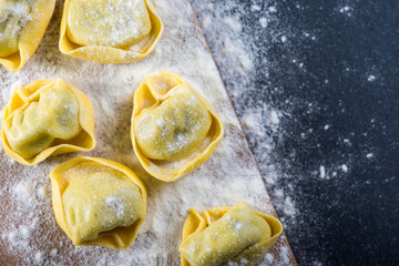 Preparation of ravioli pasta on black slate background